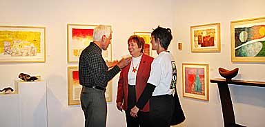 Georgia Szczublewski talks with Tony and Trish Barone at Bob Beach's Collage Show at American gallery